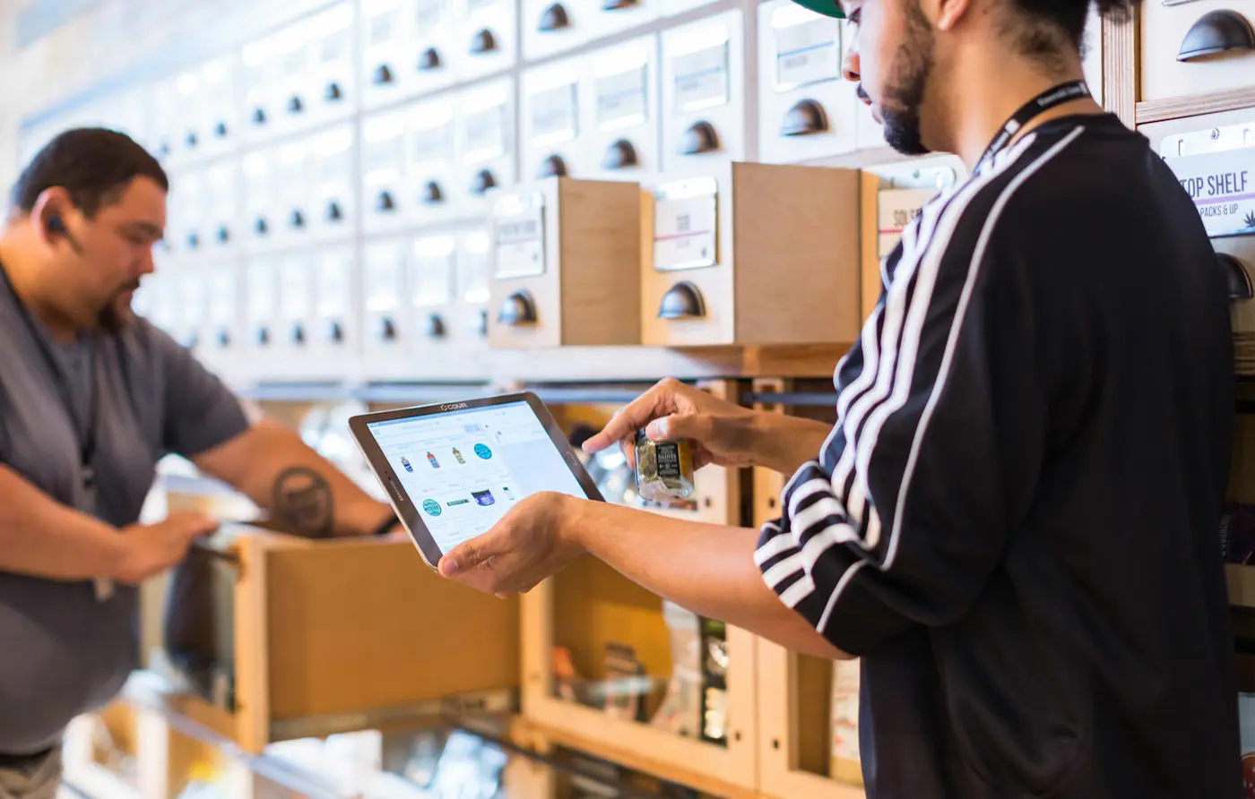 Dos personas revisan un registro en una tableta dentro de una bodega