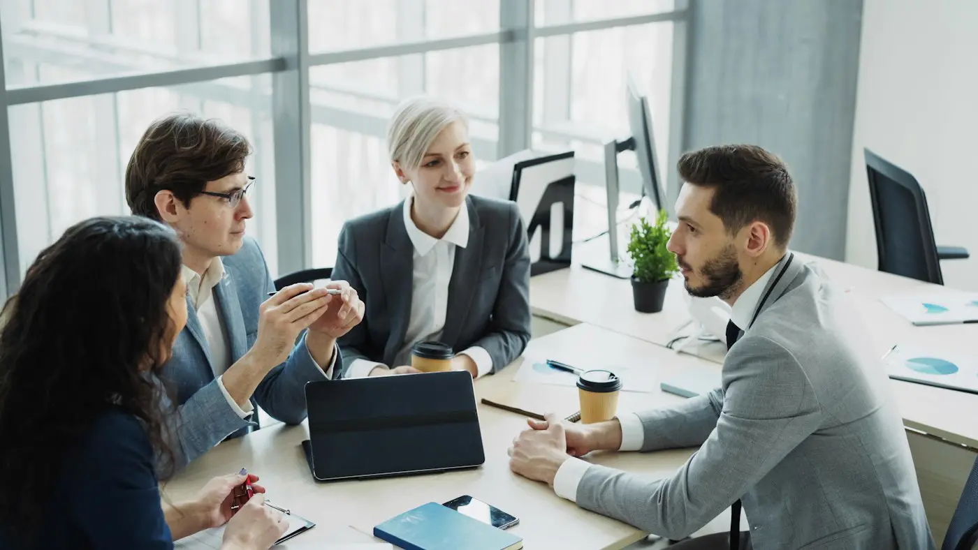 Equipo reunido alrededor de una mesa revisando un plan de trabajo